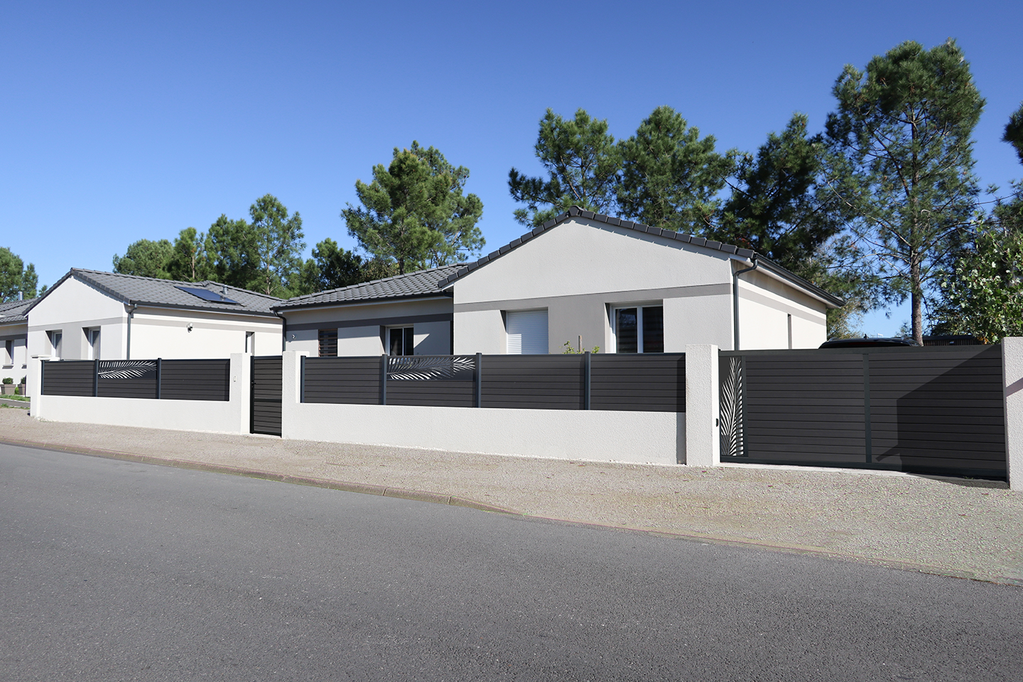 clôture tons gris sur muret avec lames décoratives en aluminium palme associée au portail et au portillon composite